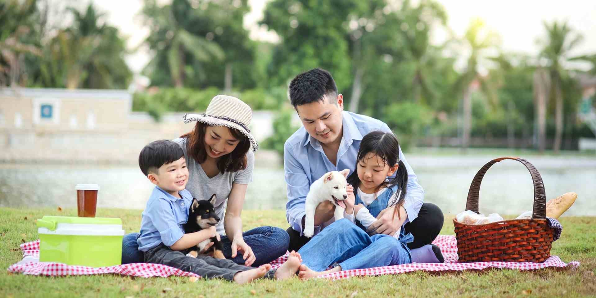 Familia compartiendo con sus mascotas por el Día del Perro.